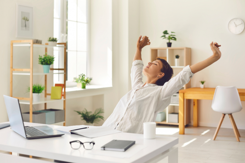 Woman stretching at her desk knowing her email marketing is sorted