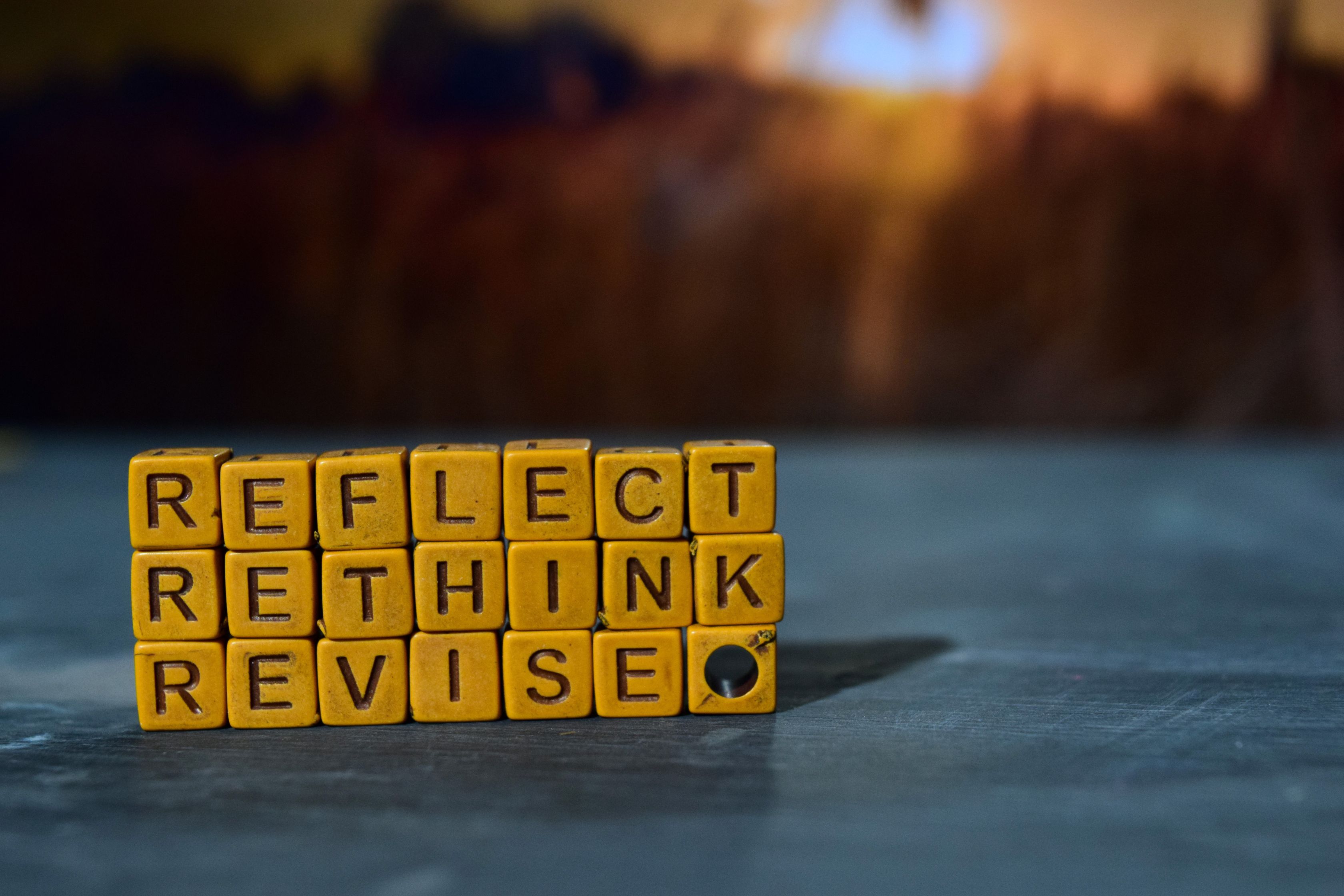 Image is words spelt out in square building blocks. The words sit on top of each other and read: Reflect, Rethink, Revise. The image is trying to convey reflecting on your 2023 email campaigns and planning for 2024