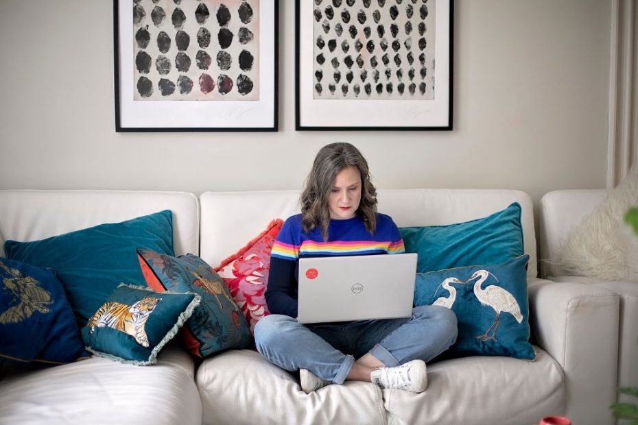 Image of Han sitting on a sofa with looking at her laptop on her lap. Unwrapping Productivity: Time-Saving Tips for the Holiday Season