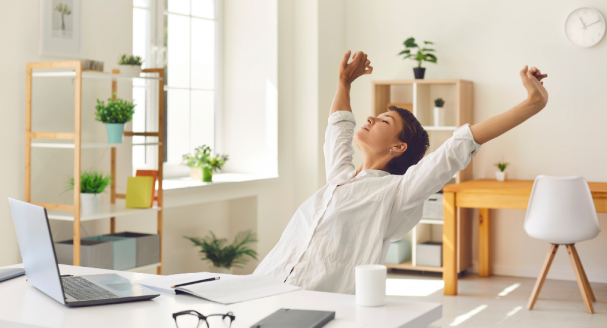 Woman stretching at her desk knowing her email marketing is sorted
